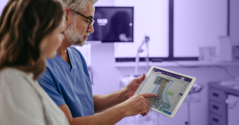 A physician goes over orthopedic medical imaging with a patient using an iPad